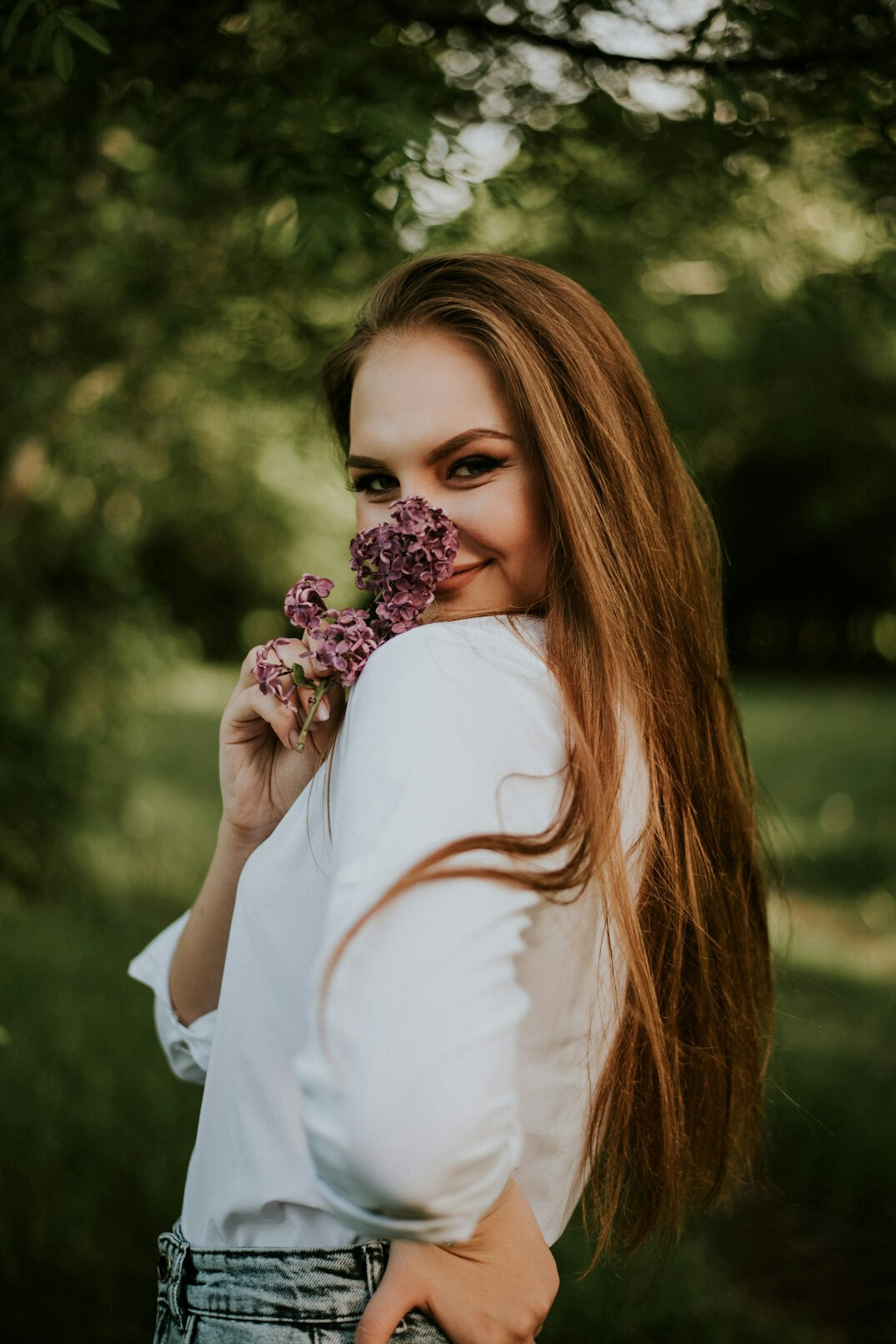 Portrait of a smiling woman with long brown hair in a white blouse