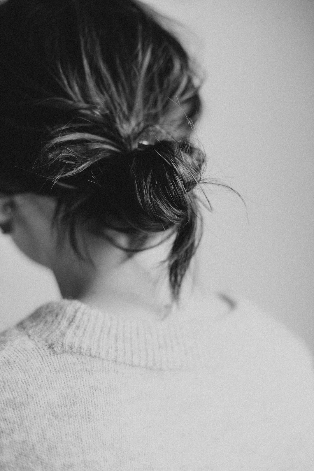 Portrait of a woman with dark hair tied back in a grey cardigan